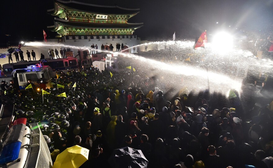 Riot police spray South Korean protestors with water cannons in front of the main gate to the Gyeongbok Palace, during a rally to commemorate the first anniversary of the Sewol ferry disaster in Seoul on Saturday.