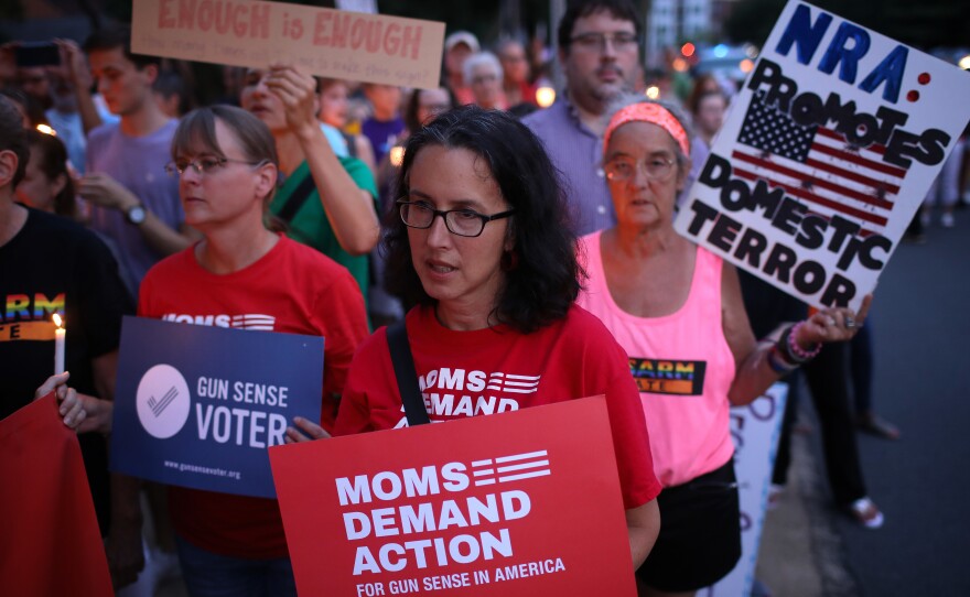 Advocates of stricter gun legislation hold a candlelight vigil for victims of recent mass shootings outside the headquarters of the National Rifle Association on Monday in Fairfax, Va.