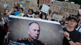 Activists hold a portrait of Ukraine's Armed Forces Commander-in-Chief Oleksandr Syrskyi demanding his resignation during a rally against President Volodymyr Zelenskyy's decision to dismiss Defense Minister Mykhailo Fedorov after six months in the post, in Kyiv, Ukraine, Saturday, July 18.