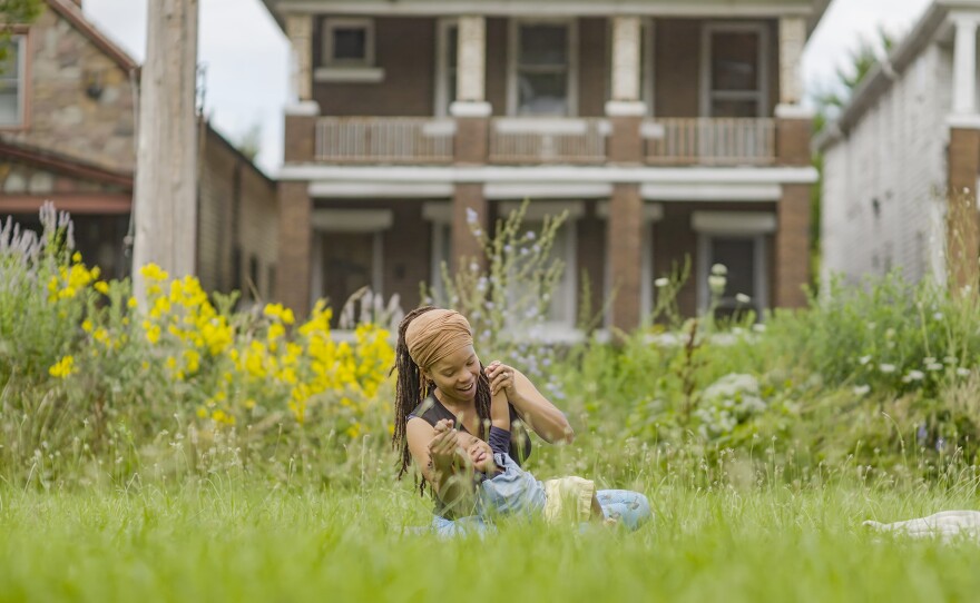 A woman and child playing in the grass.