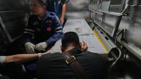 A relative of a victim in a music bar fire pays respect to the victim's body at a police hospital in Bangkok, Thailand, Tuesday, July 14, 2026.