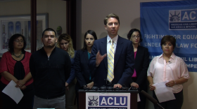 Sean Riordan (center), senior staff attorney for the ACLU of San Diego and Imperial Counties, talks to reporters about the settlement of an immigration lawsuit, August 27, 2014.