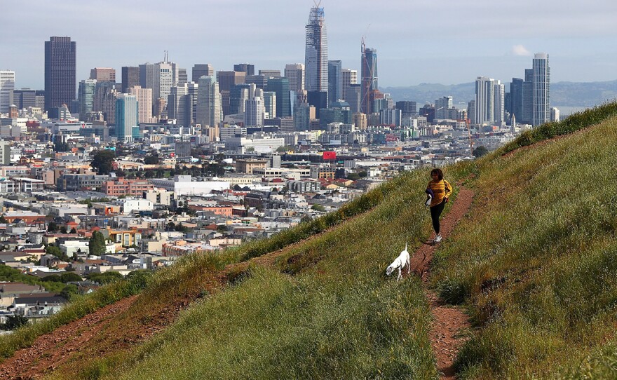 A dog walker on a dried section of Bernal Heights Park in 2014 in San Francisco (left). When Sullivan returned to the hillside this year, he was able to snap a photo of another woman walking her dog in almost the exact same spot.