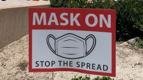 A sign requiring face covering is pictured at a beach in San Diego, July 10, 2020.