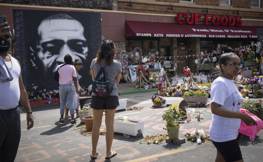 People walk through George Floyd Square on the anniversary of George Floyd's death in Minneapolis, Minn.
