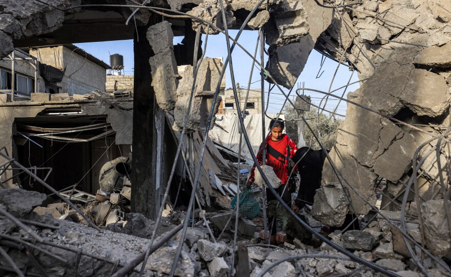 Amid the rubble of a collapsed building in Rafah, in southern Gaza, a woman and a girl search for items on April 24, following reported Israeli airstrikes overnight.
