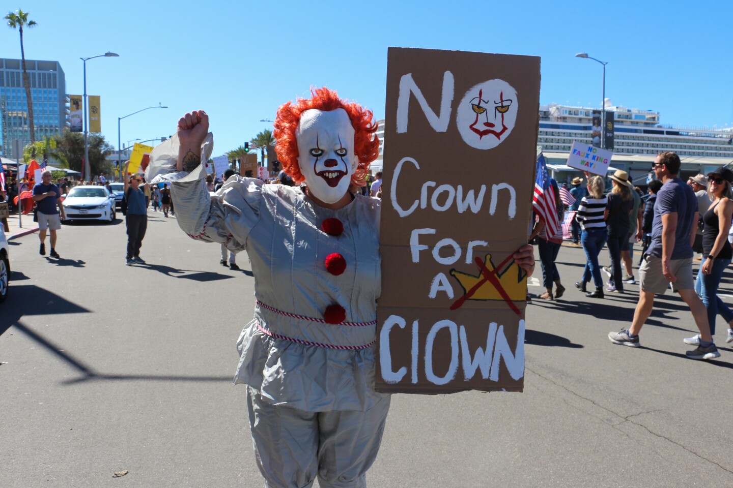 A protestor holds up a sign with his a fist in the air during a "No Kings" rally at Waterfront Park on Oct. 18, 2025.