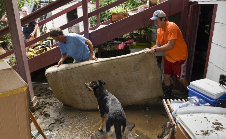 Al Miller (left) helps clear Dan Durantaye's flooded basement after heavy floods devastated the historic district of Ellicott City on Sunday.