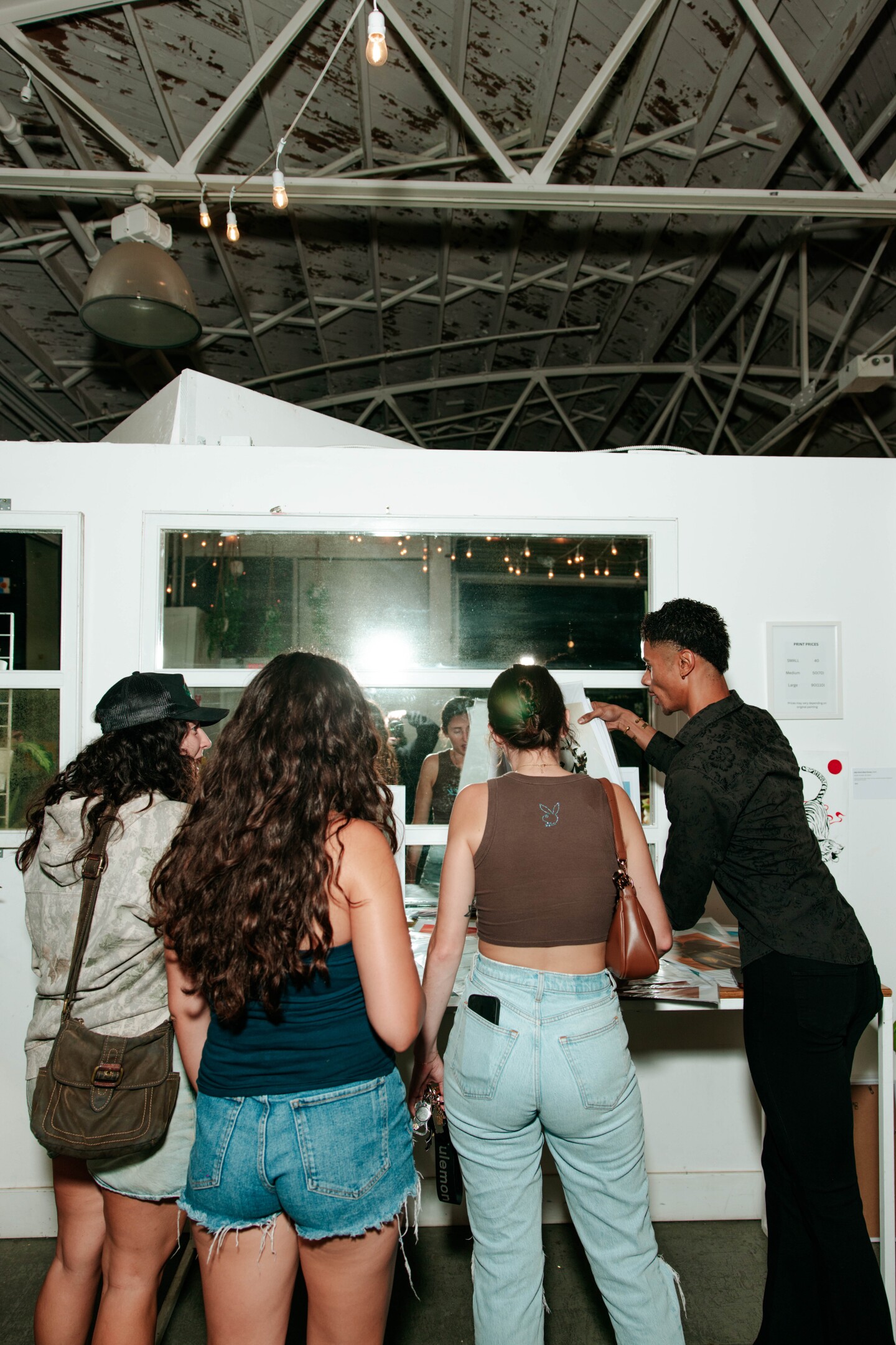 Gillis shows visitors different art pieces they can purchase at his solo exhibition in San Diego Made Factory on Sept. 28, 2025