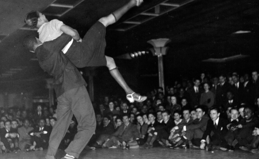 Couple competing in Savoy Ballroom Lindy Hop contest as crowd looks on in 1938.