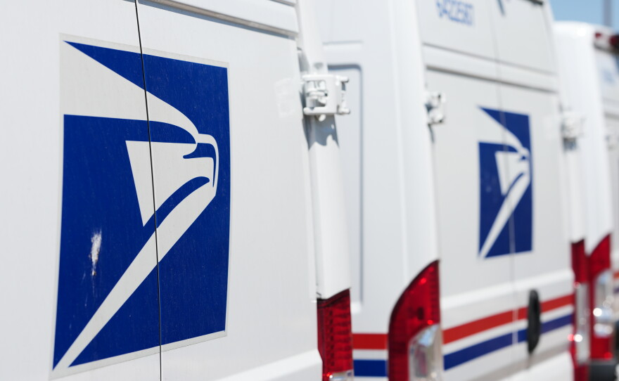 Delivery vans are parked outside the main United States Postal Service headquarters in northeast Denver on July 28.