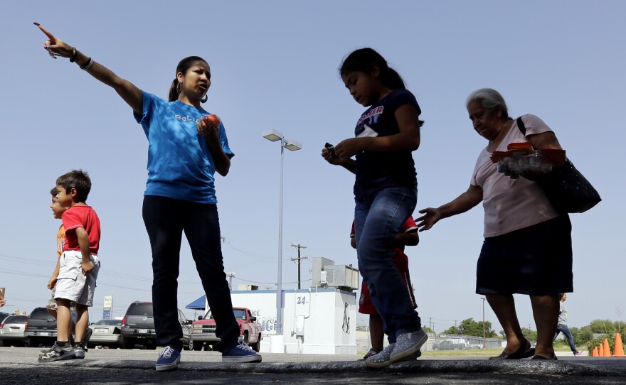 A volunteer with the Koch-funded Libre Initiative directs people in 2014 as groceries are distributed at a food bank it partially sponsors in San Antonio, Texas.