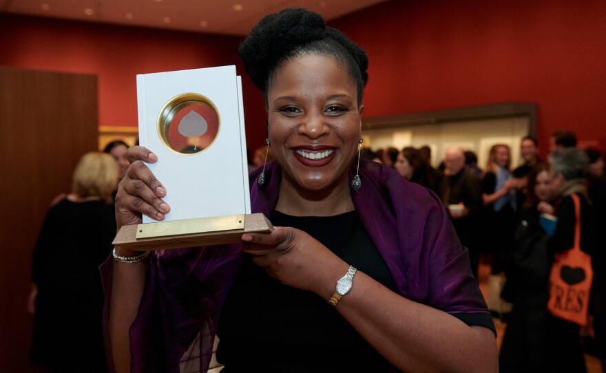 Tayari Jones holds up her Aspen Words Literary Prize, which she won Thursday in New York City for her novel An American Marriage.