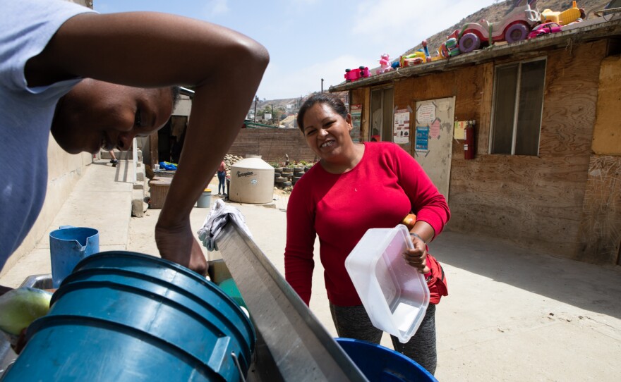 Maritza Noemi Machado Velasquez, right, washes dishes the Templo Embajadores de Jesús shelter in Tijuana, June 1, 2022. 