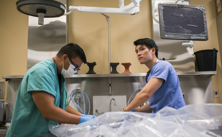 Forensic Anthropologists Kalani Carreira and Matthew Go process Korean War remains in the autopsy room at the DPAA.