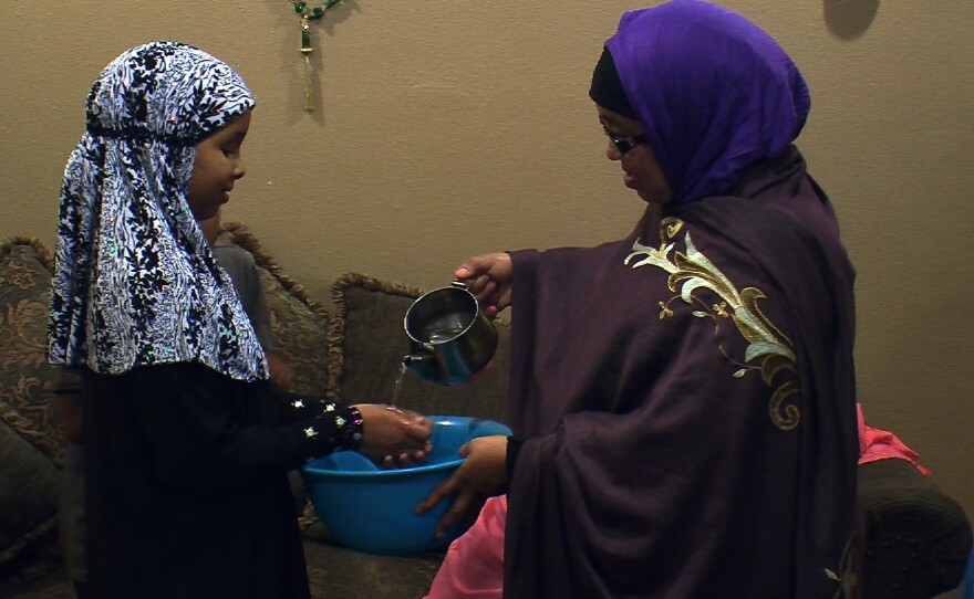 Somali refugee Mana Ahmed Mohamed helps her daughter Idil Nunow wash her hands before enjoying a traditional Somali feast.