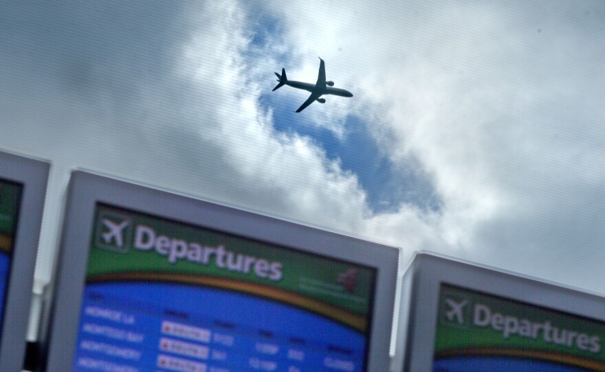 A plane takes off over a departure board at Hartsfield-Jackson Airport in Atlanta last November. Airlines say they expect an uptick in Thanksgiving travel this year.