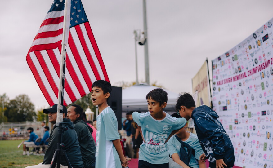 Kripal Khatiwoda, 10, (center) watches as Nepali-speaking Bhutanese men's soccer teams play in the Kalu Singh Tamang Memorial Championship in Harrisburg, Pa., on Sept. 21, 2025.