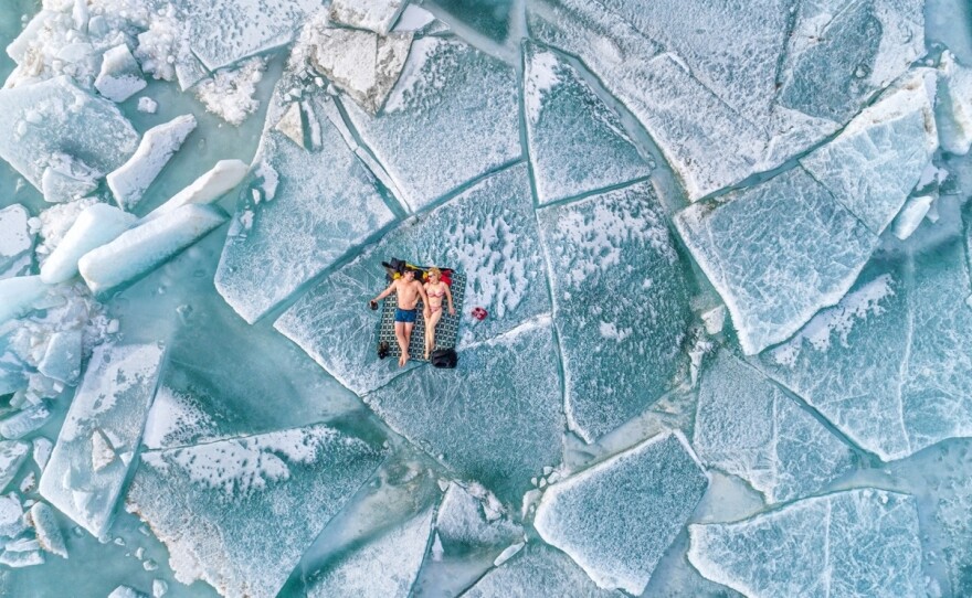 Photographer Alexandr Vlassyuk and a friend "sunbathe" on ice hummocks at the Kapchagay reservoir in Almaty, Kazakhstan. "Without waiting for summer, we decided to open the beach season!" says Vlassyuk.