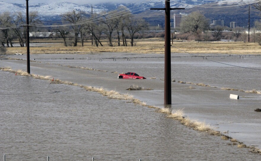 A red pickup truck sits abandoned on a closed road Monday at a University of Nevada, Reno, research farm bordering the Truckee River south of U.S. Interstate 80.