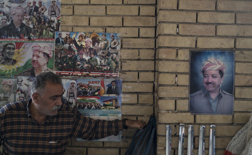 Photos of Kurdish president Masoud Barzani hang Wednesday on the walls of the central bazaar in Irbil, Iraq.