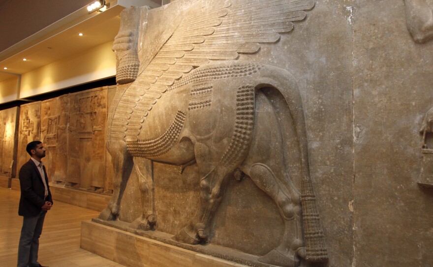 A man looks at ancient Assyrian human-headed winged bull statues at the Iraqi National Museum in Baghdad on Saturday.