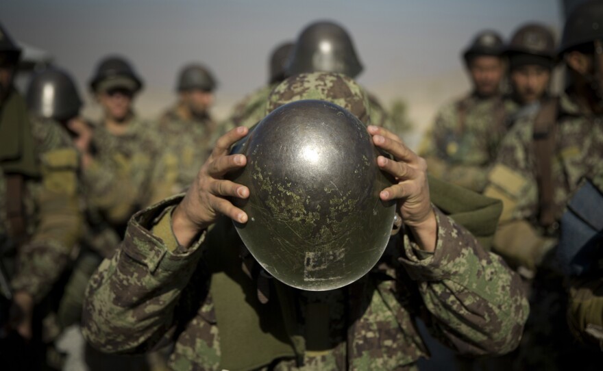 An Afghan army soldier adjusts his helmet as he lines up with others at a training facility in the outskirts of Kabul in 2013.