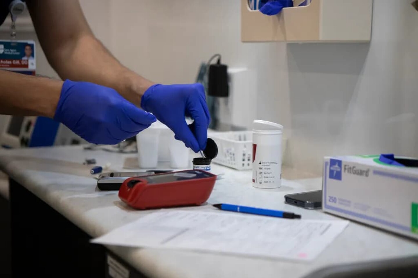 Doctor Nicholas Gill is pulling blood sugar testing strips from a container during a check-up examination in the Saint Agnes Mobile Health Unit mobile clinic, parked in the City Heritage Park parking lot in Parlier on May 16, 2025.