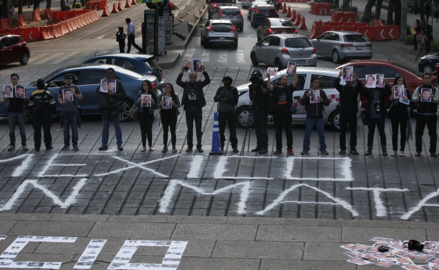 Journalists hold up photos of colleague Javier Valdez and other slain journalists during a protest to call attention to the latest wave of killings of journalists, at the Angel of Independence in Mexico City, Tuesday, May 16, 2017.
