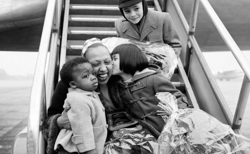 Josephine Baker is welcomed by three of her children after a tour in 1956, at Le Bourget airport near Paris.