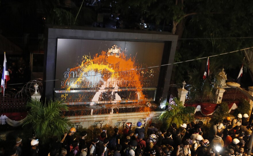 Pro-democracy protesters splash colored paint on the police headquarters sign in Bangkok, Thailand, on Wednesday.