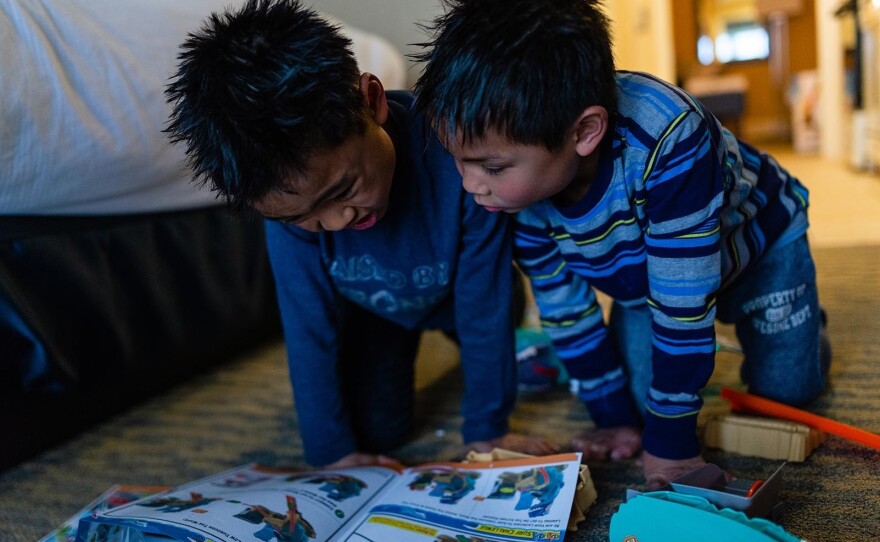 Hayle and Henry look at instructions while attempting to build a Hot Wheels set in Ocean City, Md., on April 14, 2019.