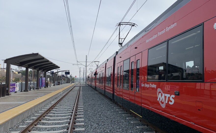 A red MTS trolley car sits at the Balboa Avenue station on the extension of the UCSD Blue Line, Nov. 18, 2021.