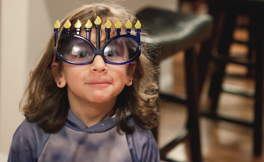 A young girl wears special Hanukkah glasses.