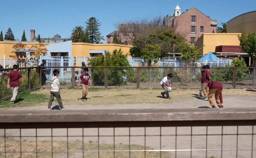 Students in International Community Elementary and Think College Now Elementary play soccer during recess on an unpaved surface at the César E. Chávez Education Center’s living schoolyard on April 29th, 2024 in Oakland, California. Unpaved surfaces let water filter into the ground and reduce air temperature. Groups also want more outdoor shade at schools. 