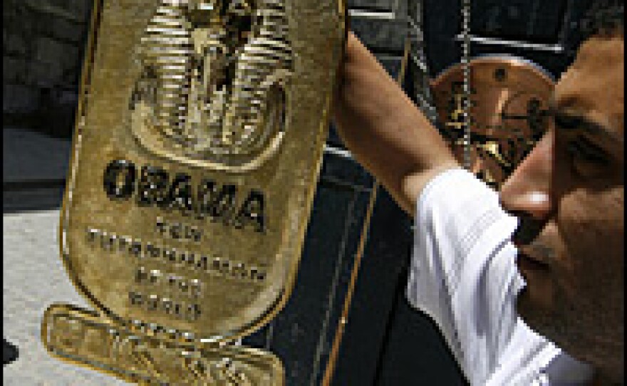 An Egyptian vendor displays a handmade copper plaque reading "Obama, New Tutankhamun of the World" at his shop in the Khan el-Khalili market area in Cairo on Monday.