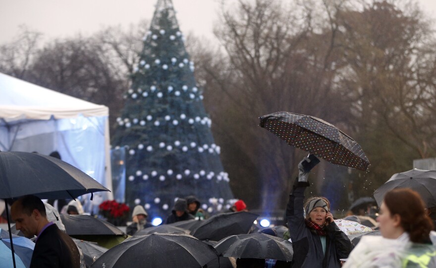 Spectators gather in the rain before President Barack Obama lights the National Christmas Tree at a ceremony at the Ellipse across from the White House in Washington, on Friday.