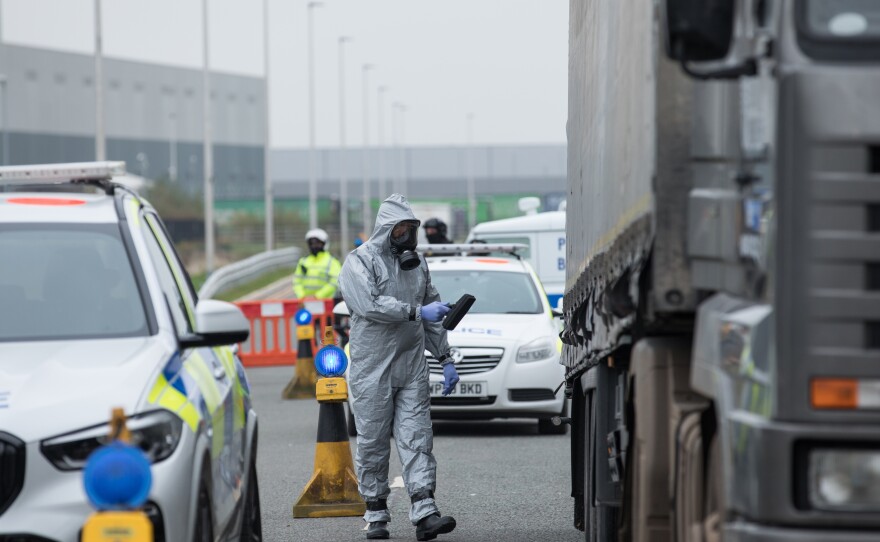 A soldier checks the radiation levels on a truck.