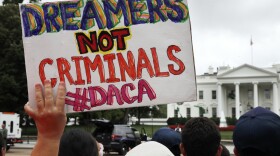 A woman holds up a signs in support of the Obama administration program known as Deferred Action for Childhood Arrivals, or DACA, during an immigration reform rally at the White House in Washington, Aug. 15, 2017. 