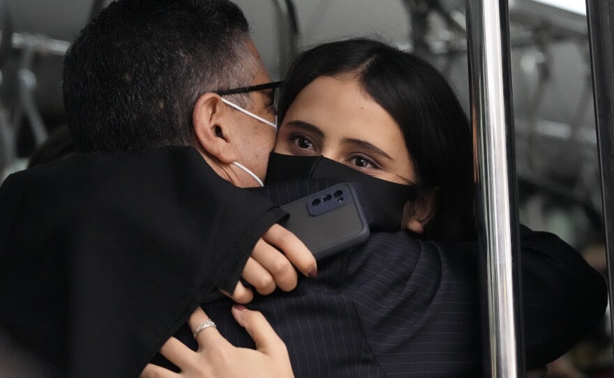 An Afghan musician hugs Ahmad Sarmast, founder and director of the Afghanistan National Institute of Music, inside a bus after she disembarked in Lisbon from the flight from Doha on Dec. 13.