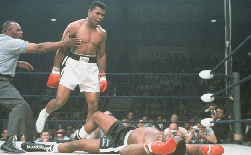 Muhammad Ali is held back by referee Joe Walcott after knocking out Sonny Liston in the first round of their championship bout in Lewiston, Maine, on May 25, 1965.