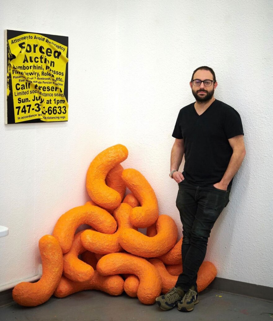 Artist Sam Keller is shown in an undated photo with a Cheetos-inspired sculpture.