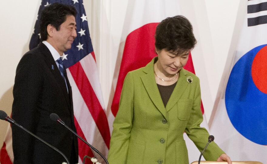 Japanese Prime Minister Shinzo Abe and South Korean President Park Geun-hye walk to their seats for the start of a trilateral meeting with the U.S. in 2014. Japan and Korea's leaders have yet to meet one-on-one.