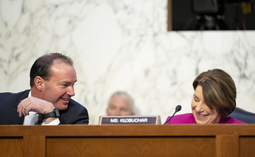 Sen. Mike Lee, R-Utah, left, speaks with Sen. Amy Klobuchar, D-Minn., during the Ticketmaster hearing on Jan. 24.