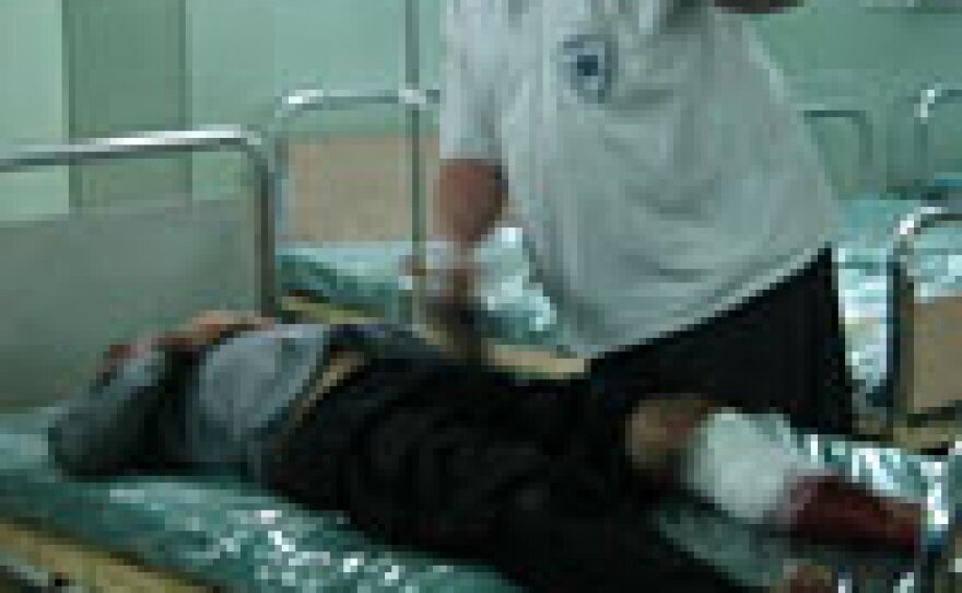 At the hospital, paramedic Ahmed Abdu Khadi comforts a guard shot while trying to fend off a robbery at a private home.