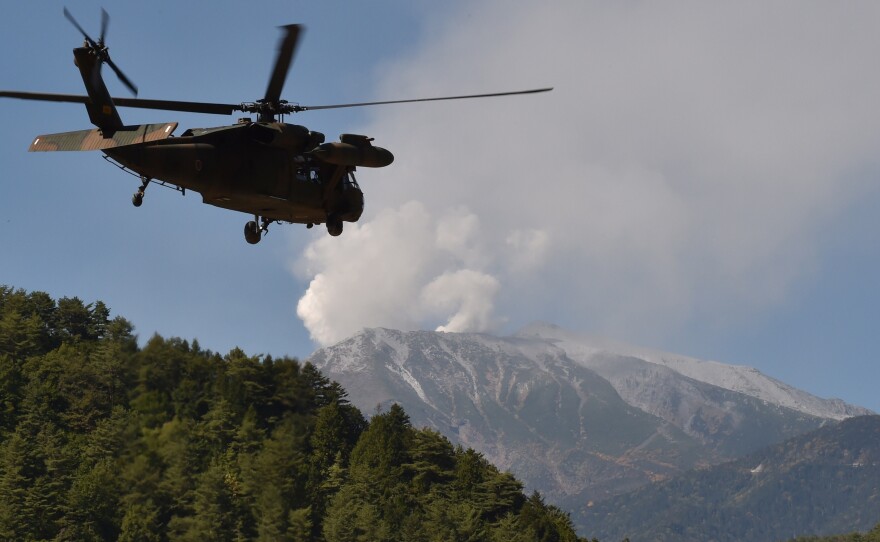 A military helicopter leaves a temporary landing site for a rescue mission on Mt. Ontake in Nagano prefecture Monday. Rescue efforts had to be suspended today, due to toxic gases being vented by the volcano.