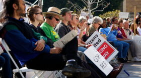 Several people listen to a speaker express her opposition to the Citizens United ruling at an Occupy Courts protest in Los Angeles, 2012.