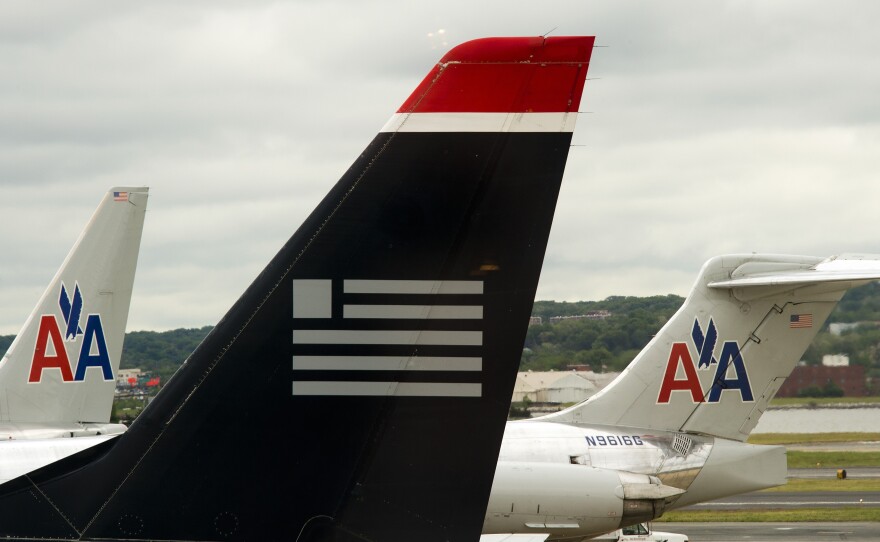 A US Airways plane rests near two American Airlines jets at Ronald Reagan Washington National Airport last year. The combined carrier would be named American Airlines.
