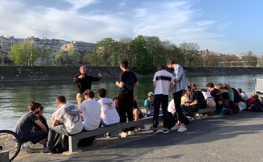 Young people gathered Wednesday by the Seine River in Paris, largely without masks and without social distancing. French President Emmanuel Macron has ordered the country into a third lockdown because of the continued spread of COVID-19.