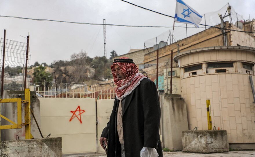 A Palestinian man walks past an Israeli checkpoint in Hebron on Dec. 24.